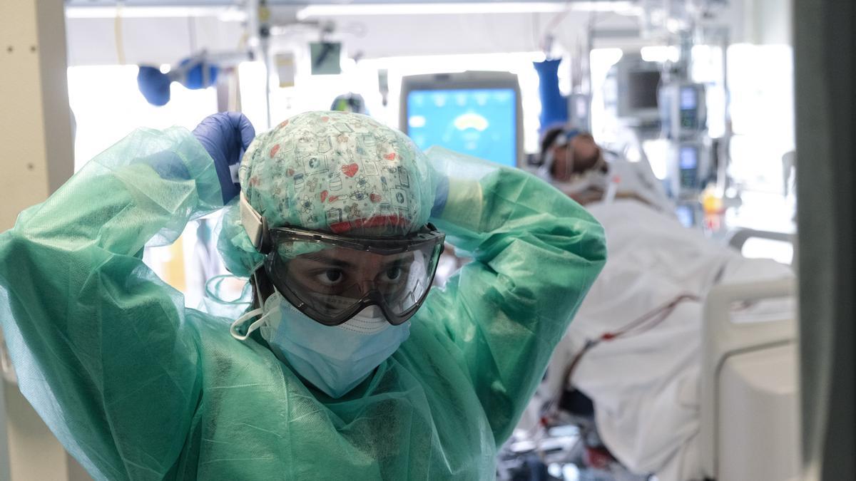 Sanitario colocándose un equipo EPI completo en el Hospital de Torrevieja