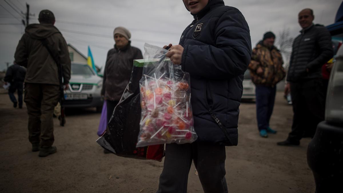 Un niño sonríe tras recibir una bolsa de piruletas, en el pequeño pueblo de Rozhivka, a unos 40 kilómetros al noreste de Kiev, Ucrania.