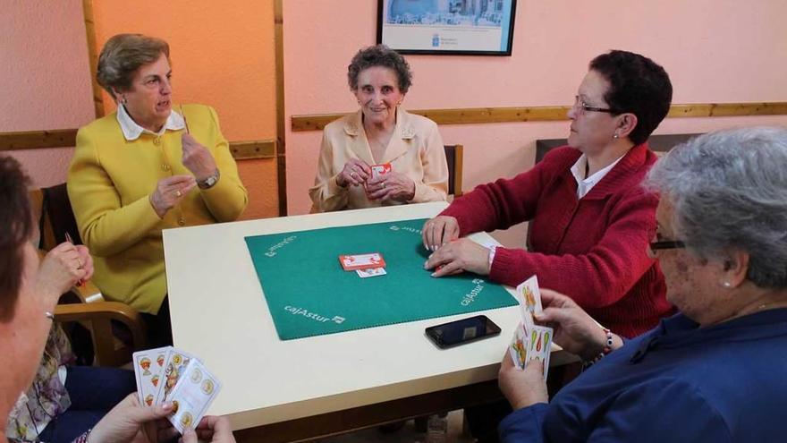 Irene Álvarez, en el centro, jugando a la brisca en el hogar del pensionista de Lugones junto a las incondicionales de su tertulia diaria.