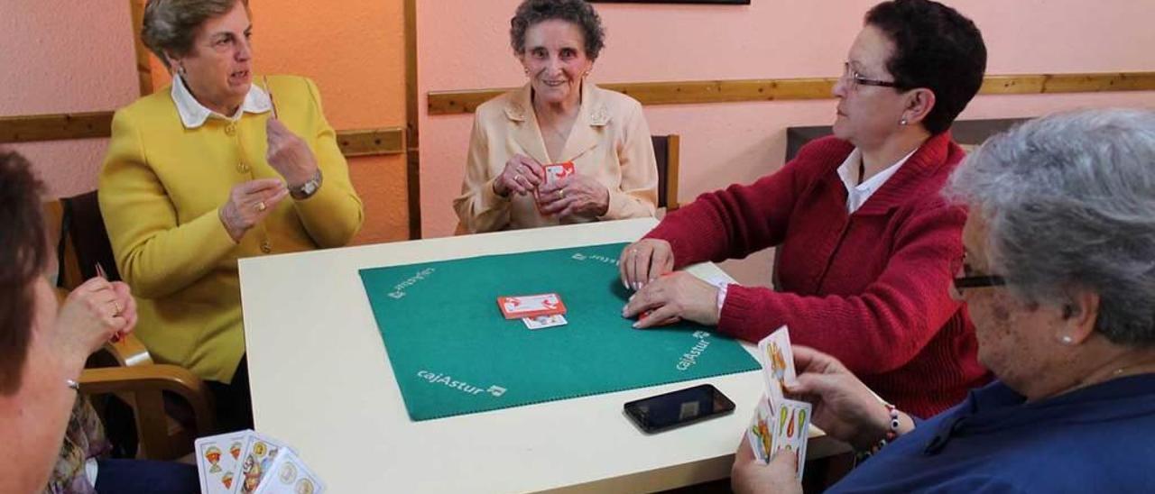 Irene Álvarez, en el centro, jugando a la brisca en el hogar del pensionista de Lugones junto a las incondicionales de su tertulia diaria.