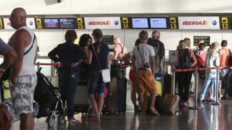 Pasajeros facturando sus equipajes, ayer, en los mostradores de Vueling, en la terminal del aeropuerto de El Altet.