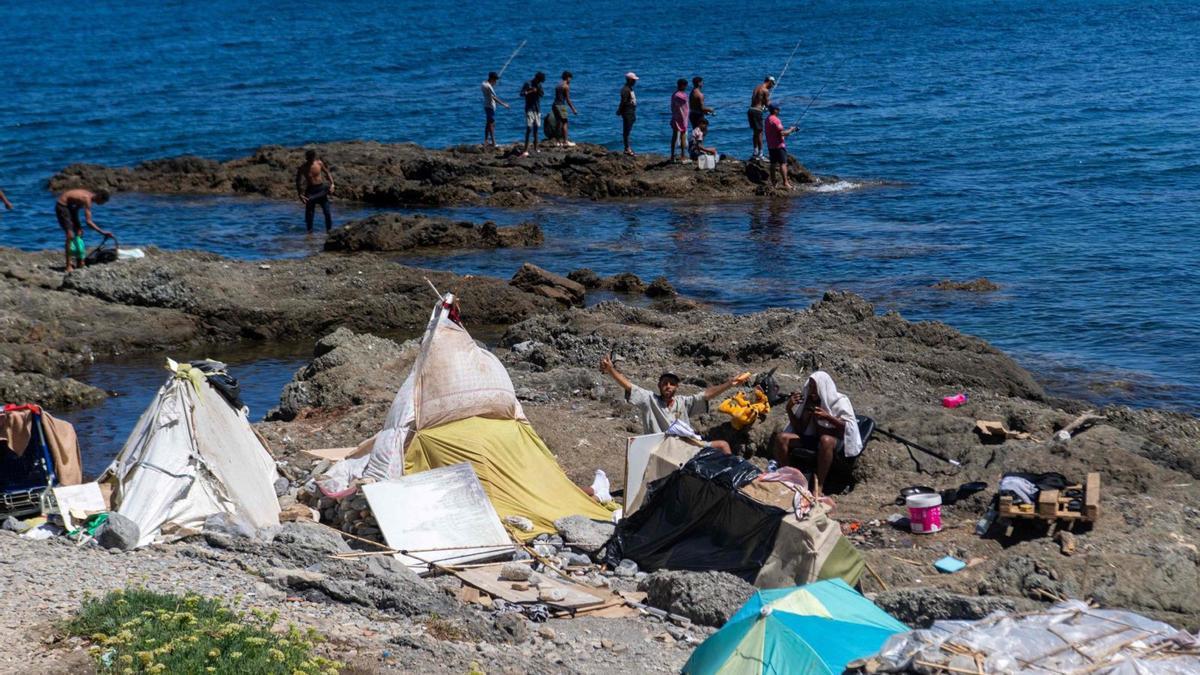 Migrants acampats en una zona rocosa del litoral de Ceuta.  | ANTONIO SEMPERE / AFP