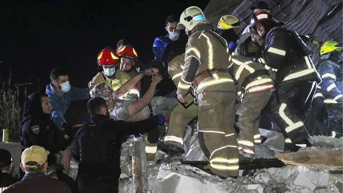 Rescatistas ucranianos trabajan en un lugar del impacto de un cohete en el área de Dnipro, Ucrania central, anoche.