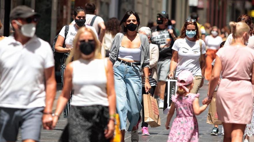 Gente de compras con mascarilla por el centro de Santa Cruz.