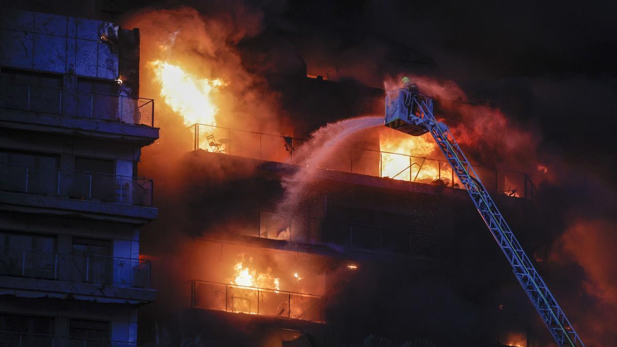 Los bomberos intentan rescatar a vecinos atrapados por el fuego en incendio en Valencia