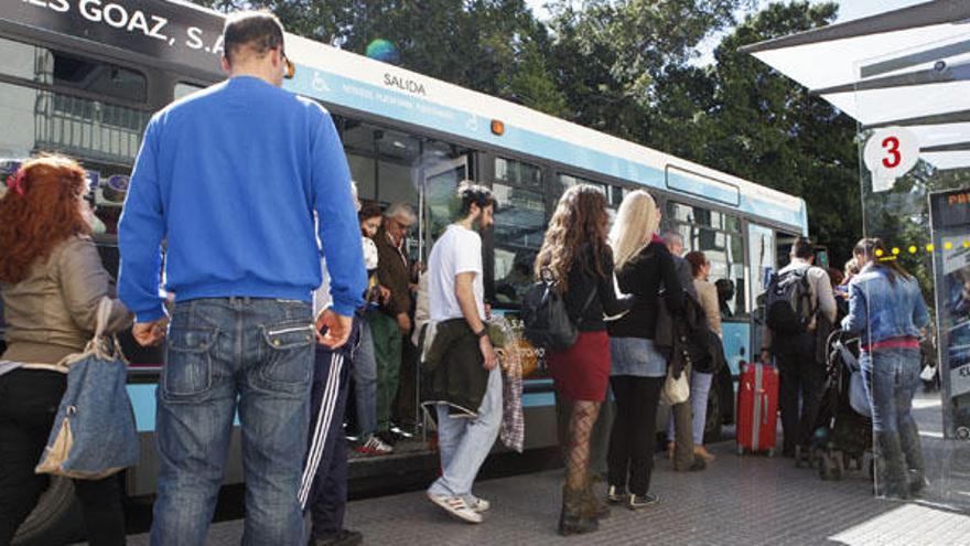 Numerosos viajeros suben y bajan de un autobús en la Alameda.