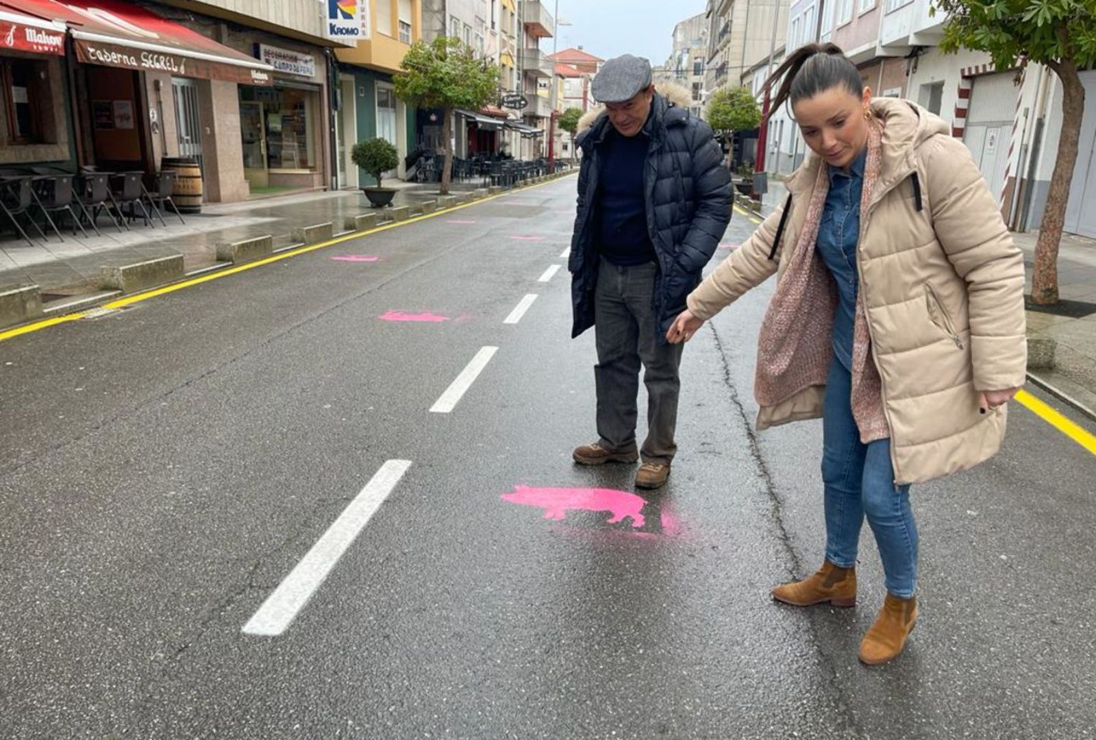 Crespo y Blanco observan, ayer, los cerdos impresos sobre el pavimento de la calle Rosalía de Castro.