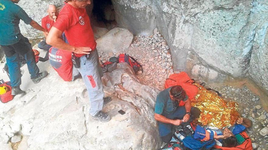 Bomberos y guardias civiles atienden al excursionista herido.