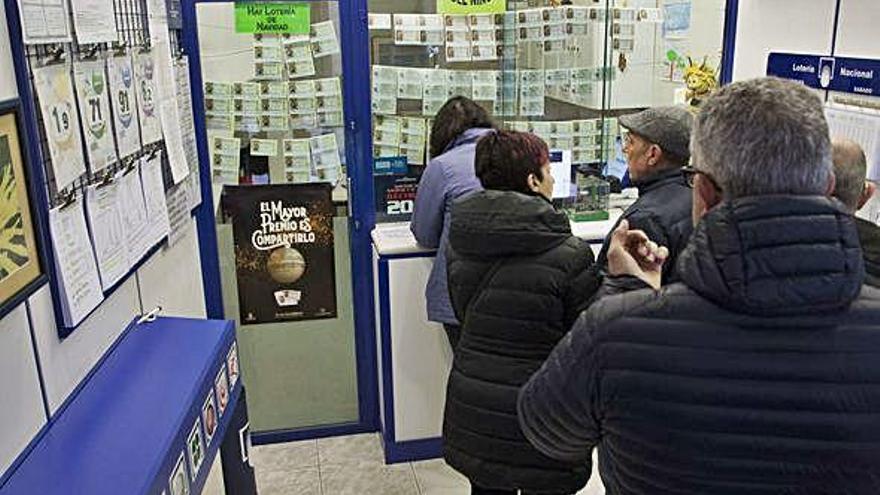 Varias personas hacen cola para comprar lotería de Navidad.