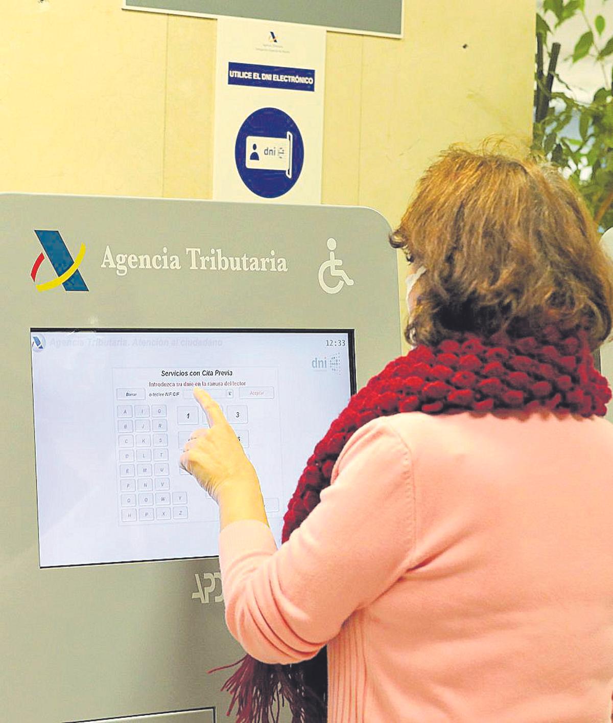 Una contribuyente solicita cita previa en una oficina de la Agencia Tributaria.