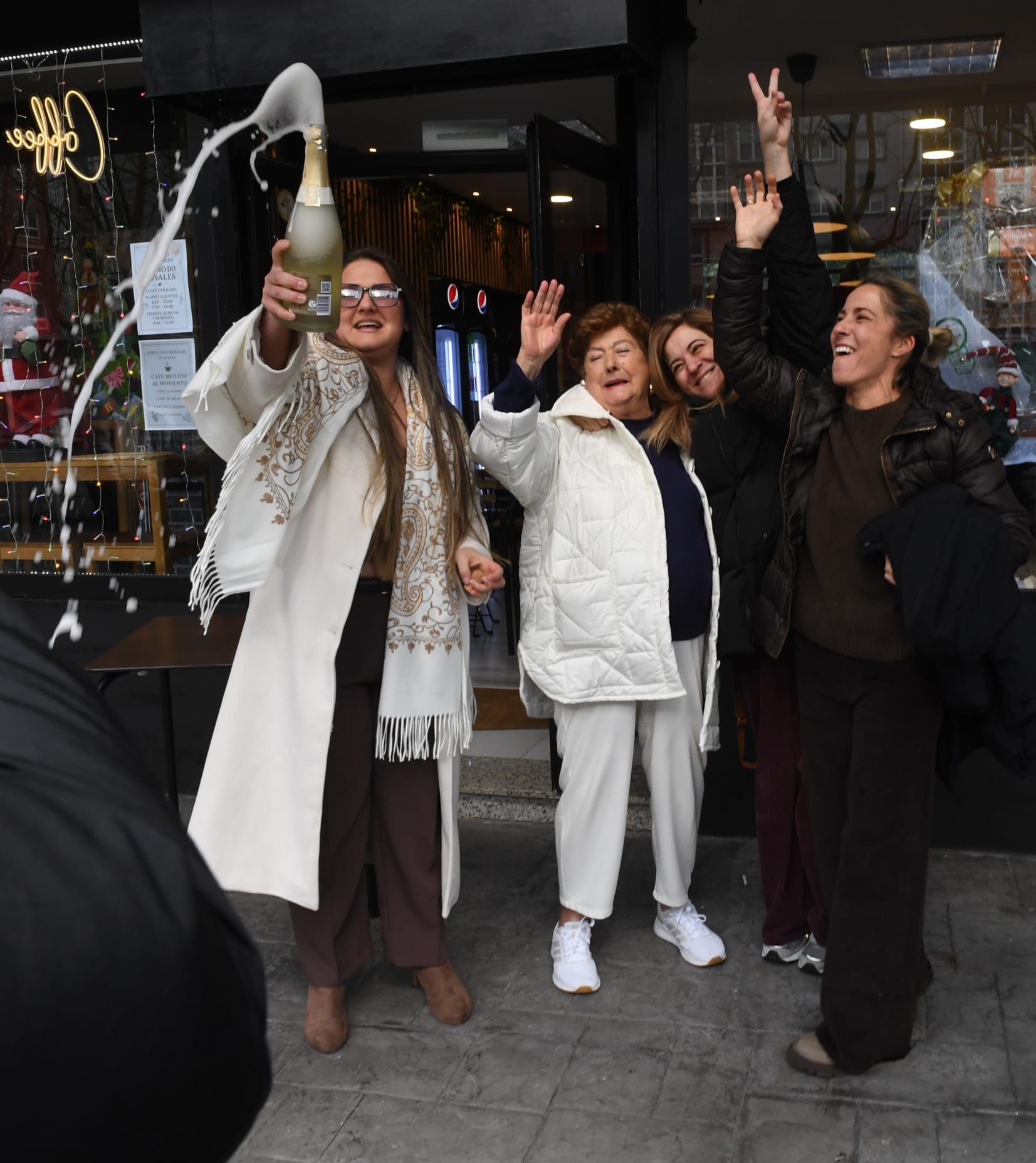 Propietaria y clientas de Forno dos Rosales en A Coruña celebran el tercer premio de la Lotería de Navidad.