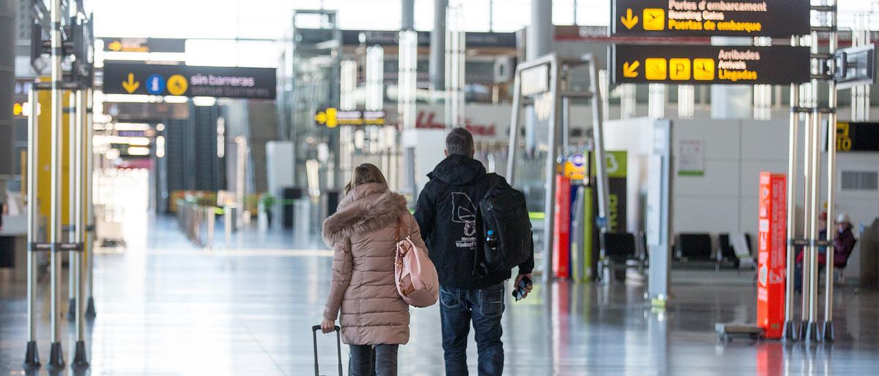 Dos pasajeros caminan por una desierta terminal en los meses duros del confinamiento