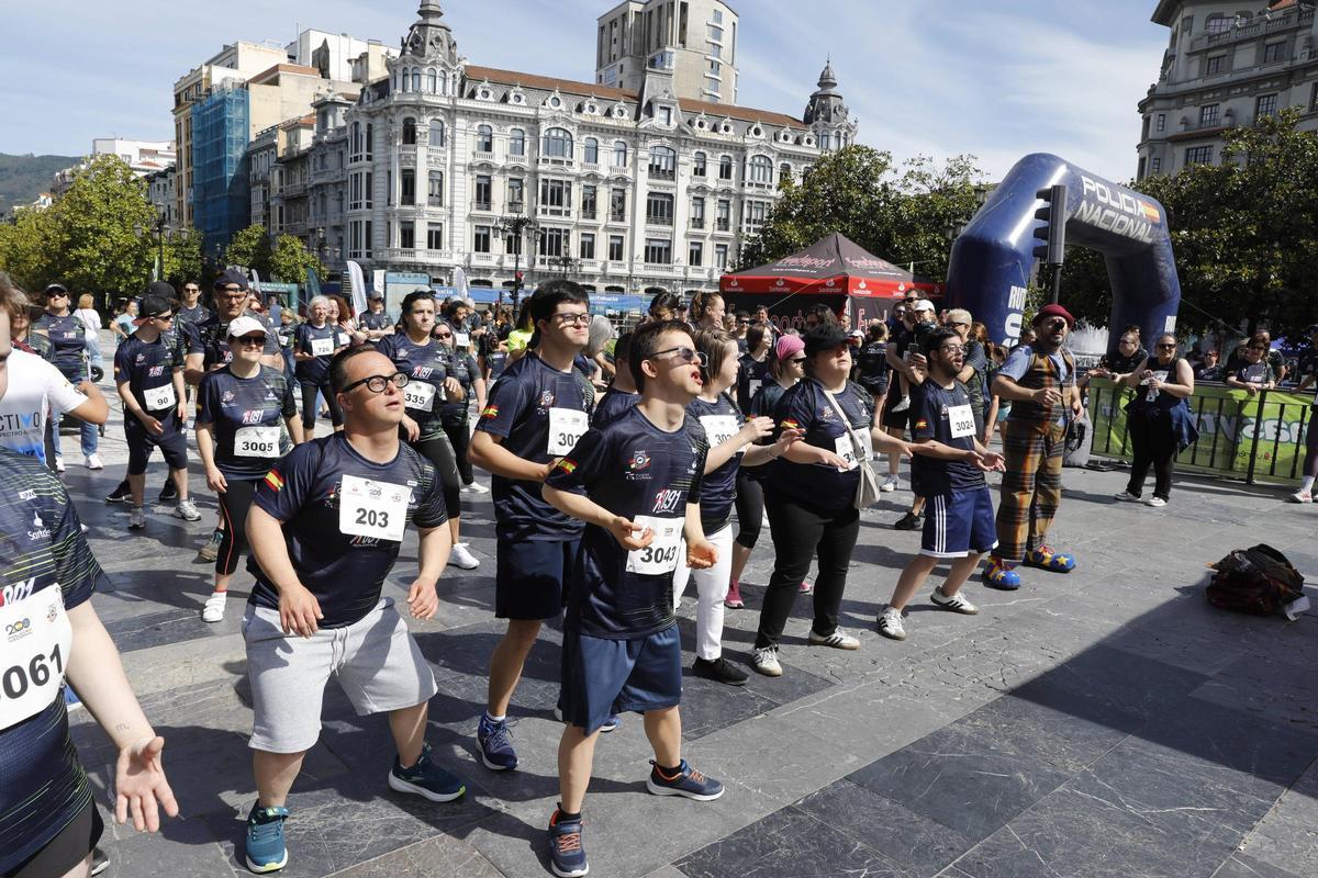 Participantes en la carrera inclusiva bailan antes del inicio de la prueba.