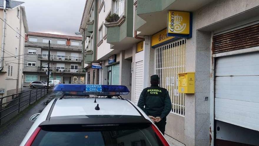 Un agente ante la oficina de Correos de Vilalonga.  // Guardia Civil