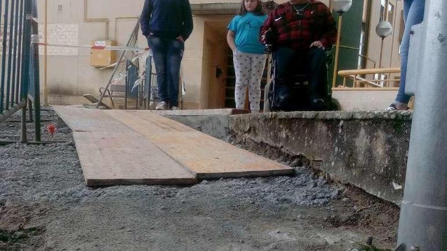 El vecino, con su hija y su nieta, junto a las tablas instaladas como acceso.