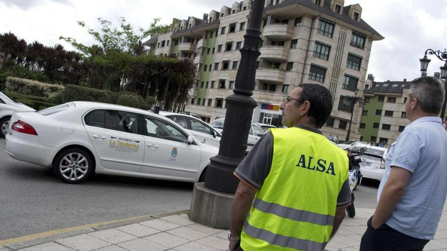 Empleados de las empresas de autobuses observan la manifestación de los taxistas ante la estación.