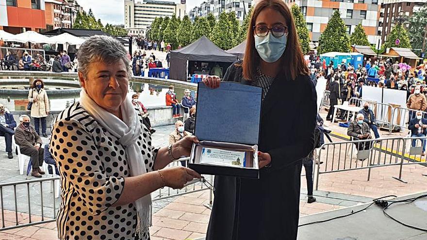 Adelita Fernández recibe una placa de manos de Covadonga Díaz durante el homenaje póstumo a Diamantina Rodríguez. | M. López / 