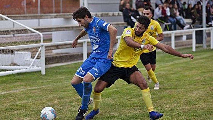 Noel trata de proteger el esférico del acoso de un adversario.