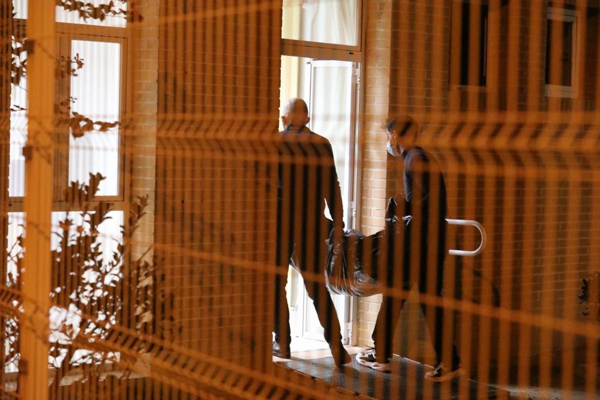 Dos operarios trasladan el cuerpo sin vida de uno de los residentes fallecidos