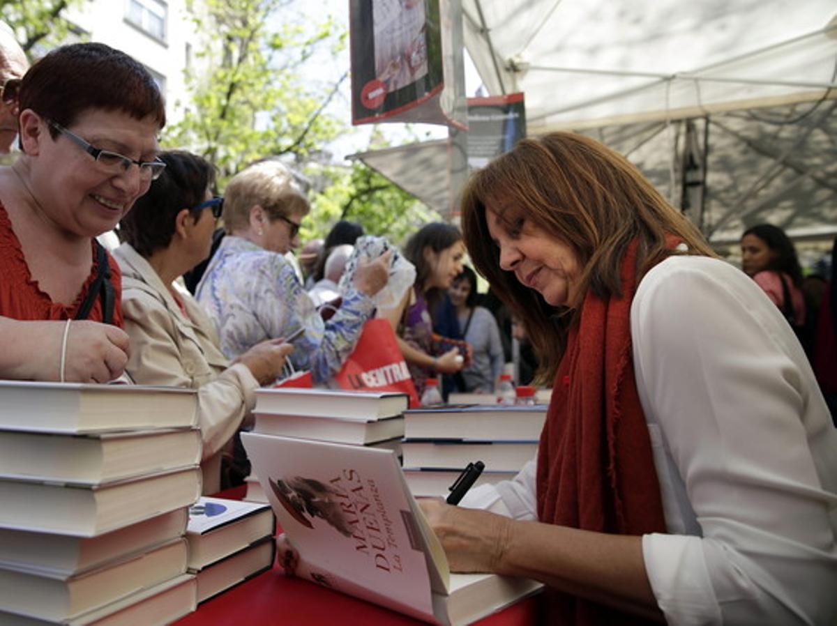 La escritora María Dueñas firma un libro en una de las paradas instaladas con motivo de la Diada de Sant Jordi. La escritora María Dueñas firma un libro en una de las paradas instaladas con motivo de la Diada de Sant Jordi.
