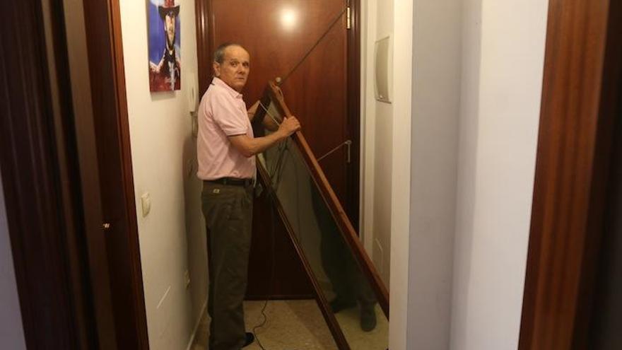 José Fernández muestra la puerta atrancada de su casa por temor al acoso continuo de una vecina.  El vendedor de almendras ha llegado a dormir en el descansillo para no escuchar los ruidos.