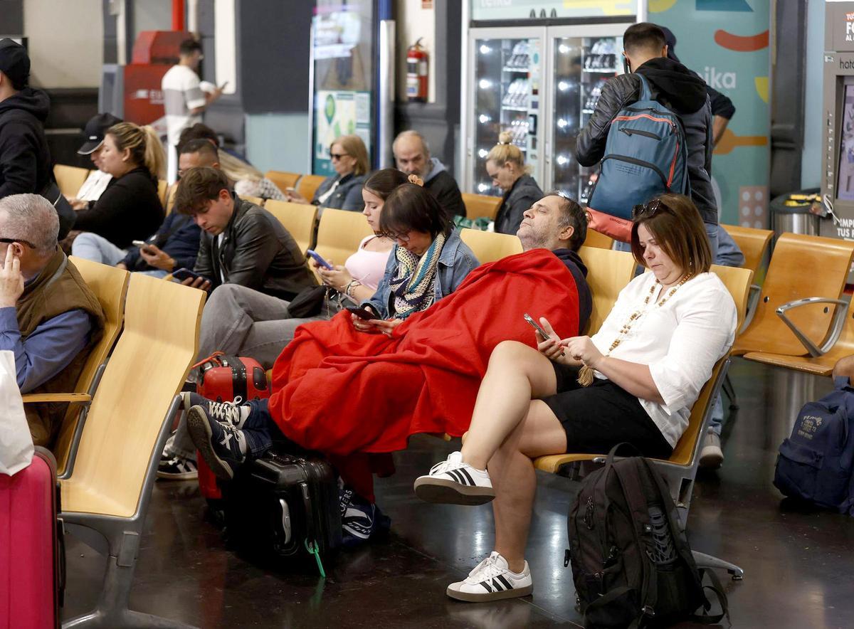 Un pasajero tapado con una manta en la estacion de Alicante