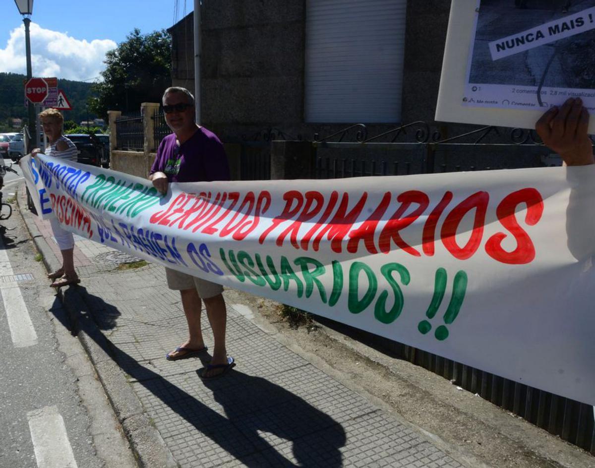 Vecinos con uno de los carteles, ayer.   | // GONZALO NÚÑEZ