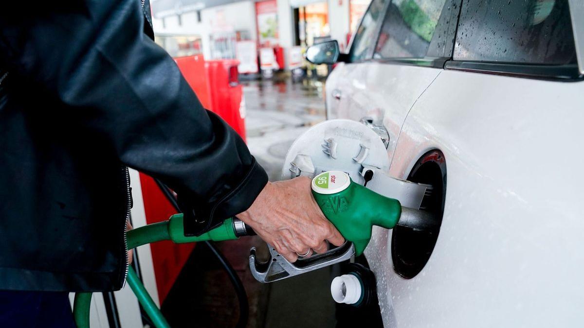 Una mujer reposta en una gasolinera.