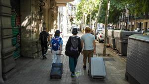 Turistas en las calles de Barcelona rumbo a su alojamiento.