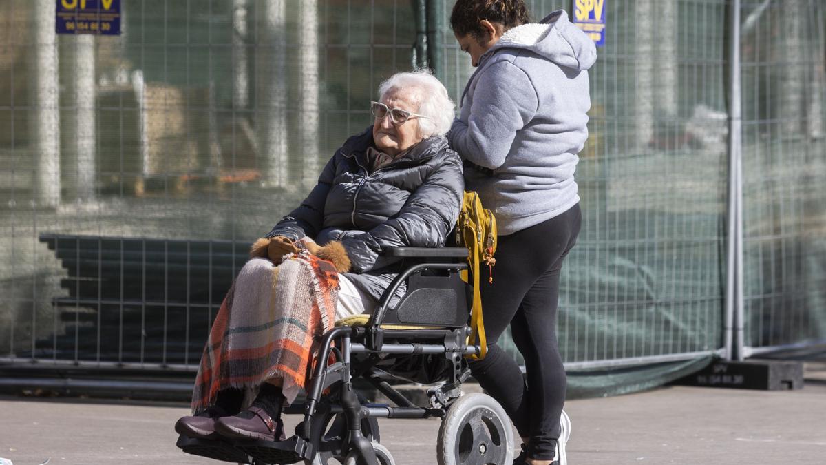 Una mujer mayor junto a su cuidadora en València, en una fotografía de archivo