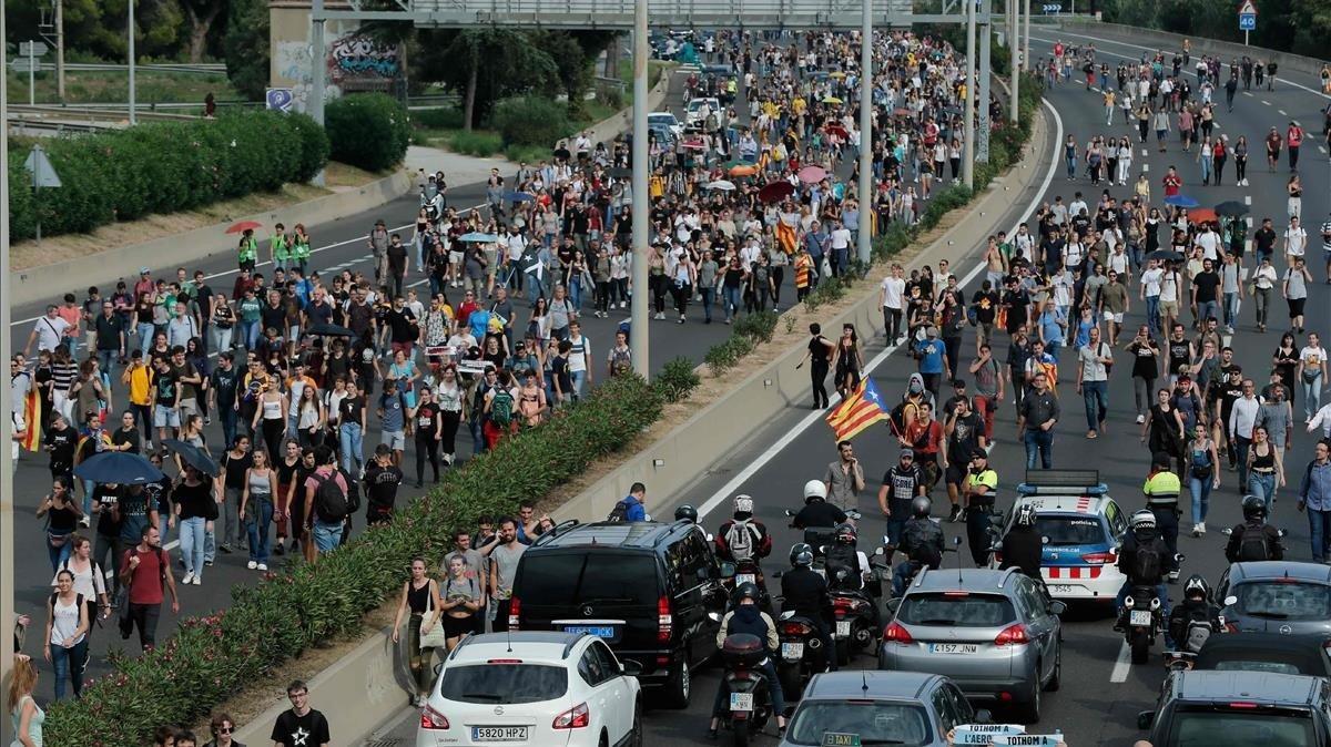 Autopista al aeropuerto de El Prat con gente caminando por la misma