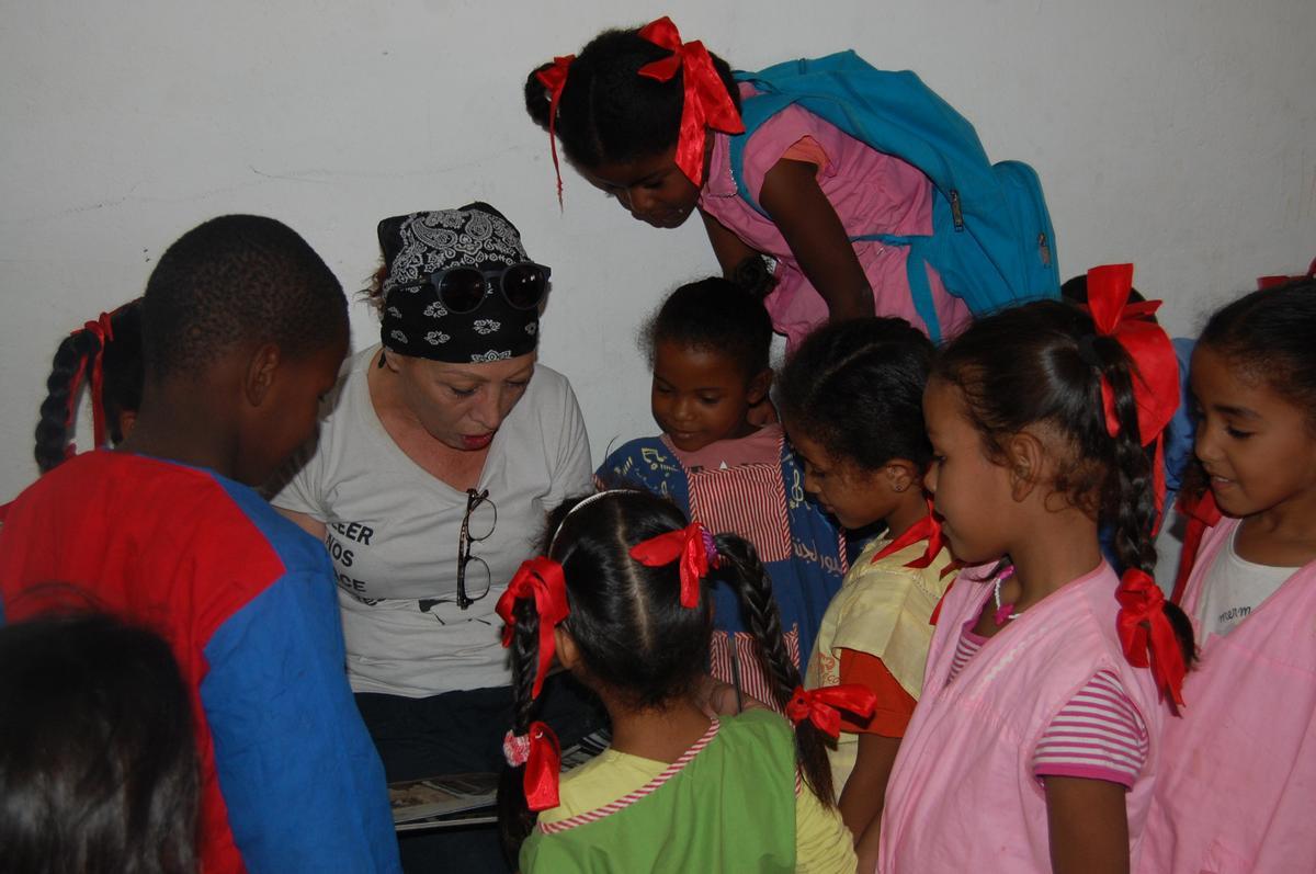 Palma Aparicio leyendo con un grupo de niños saharauis