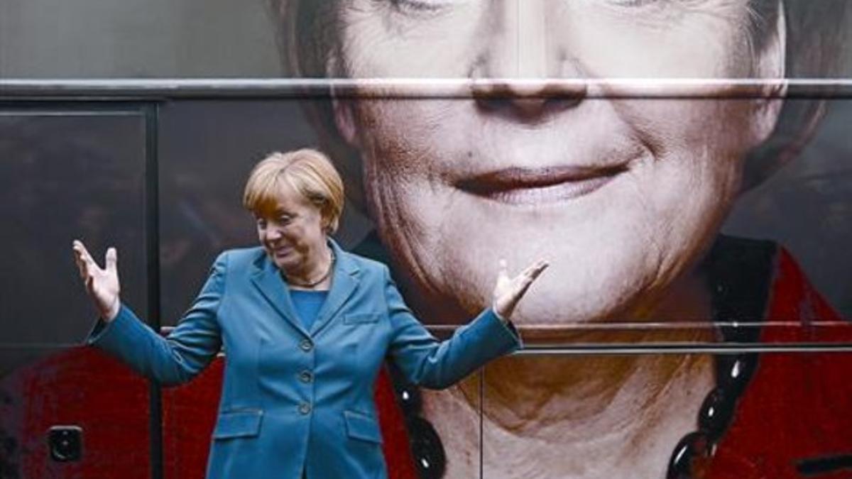 Merkel, con su cartel electoral al fondo, en un acto de campaña en Berlín, ayer.