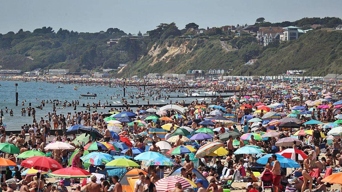 Una multitud abarrota la playa inglesa de Bournemouth ayer, el día más caluroso del año.