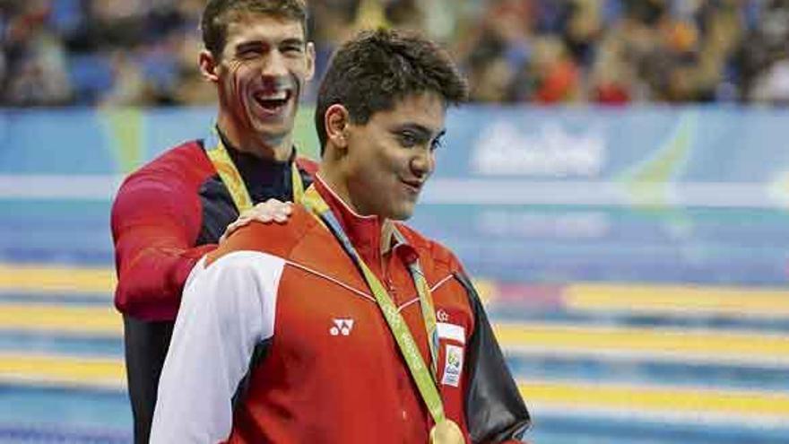 Phelps, al fondo, bromea con Schooling, que le acababa de ganar en los 100 mariposa.