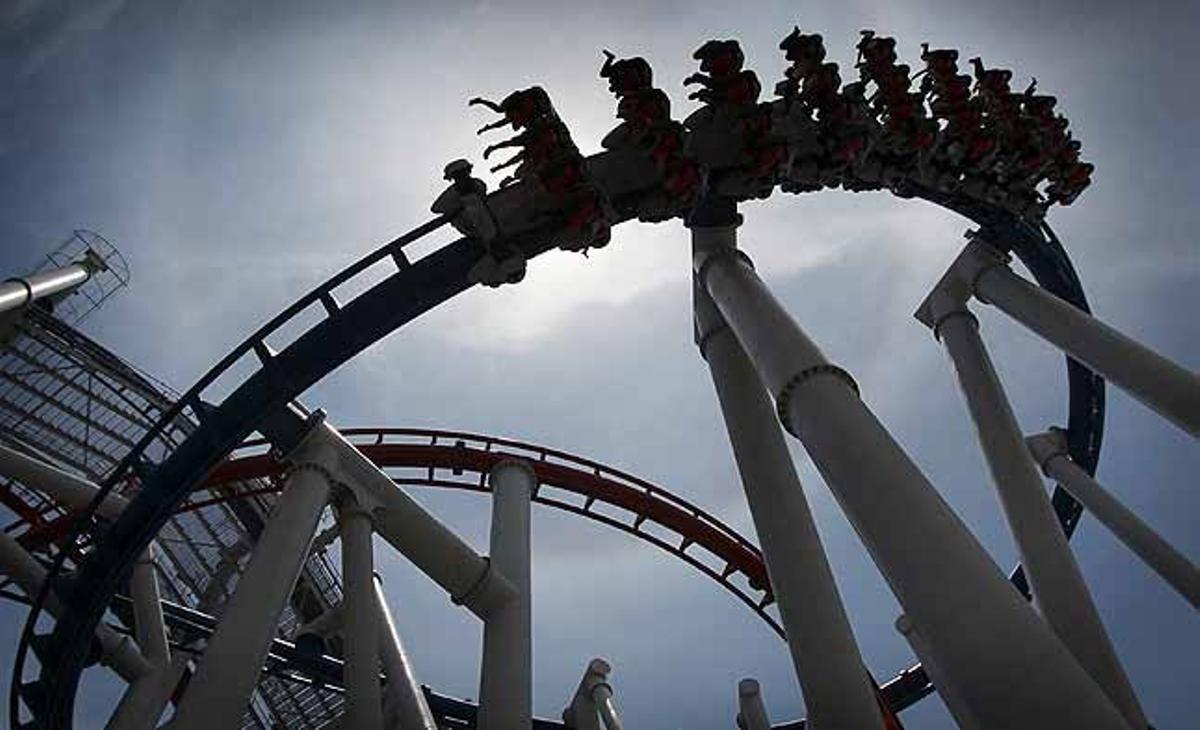 Les cames dels passatgers de la muntanya russa ’Battlestar Galactica’ dibuixen les seves siluetes contra el cel de Singapur.