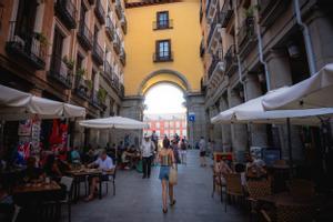 Una joven camina hacia uno de los accesos a la Plaza Mayor de Madrid. 