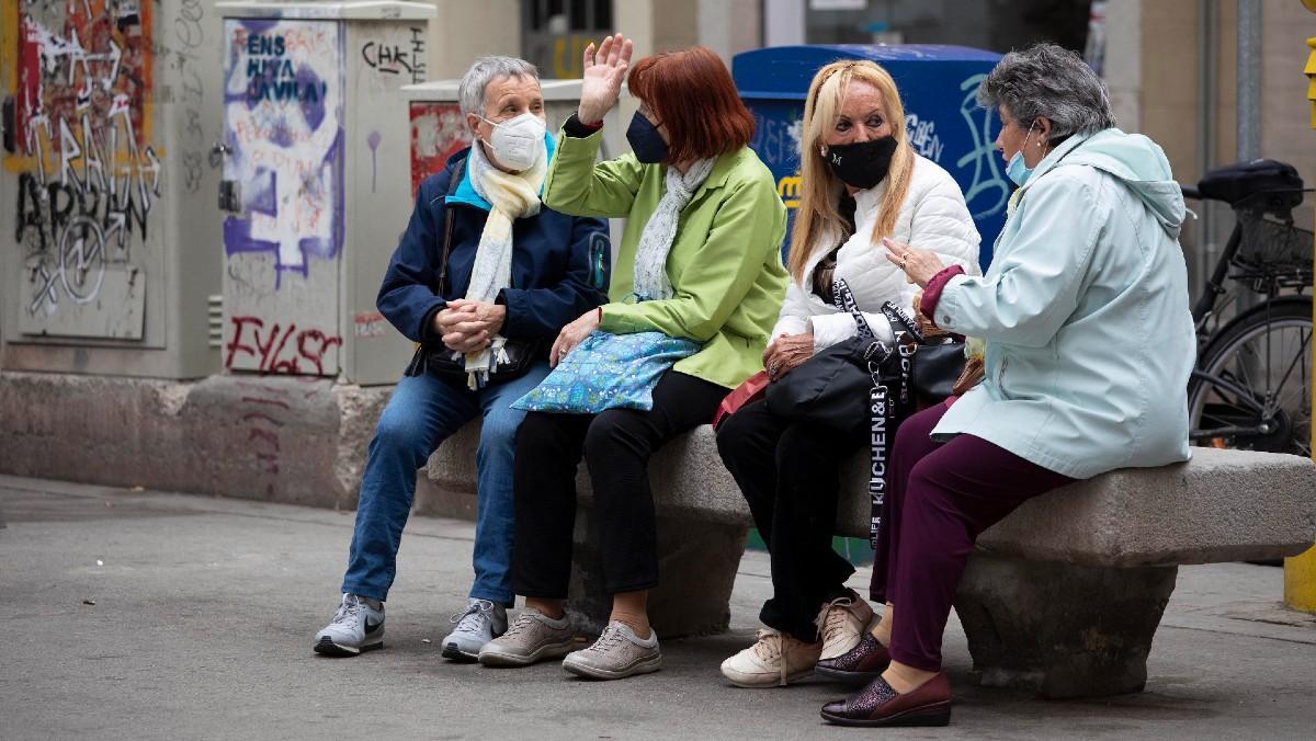 Mujeres conversan en un banco de la Vila de Gràcia, en Barcelona.