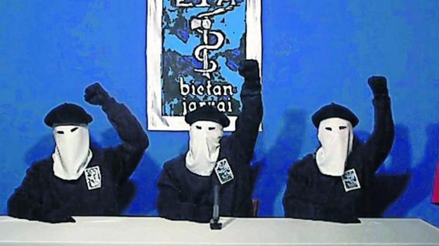 Los tres encapuchados levantan el puño tras leer el comunicado. El del centro ha sido identificado como David Pla.