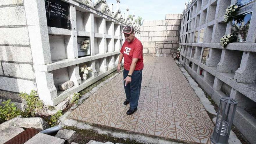 Un vecino, ayer, en el camposanto de Priegue, entre zanjas en el pavimento y nichos agujereados. // Adrián Irago