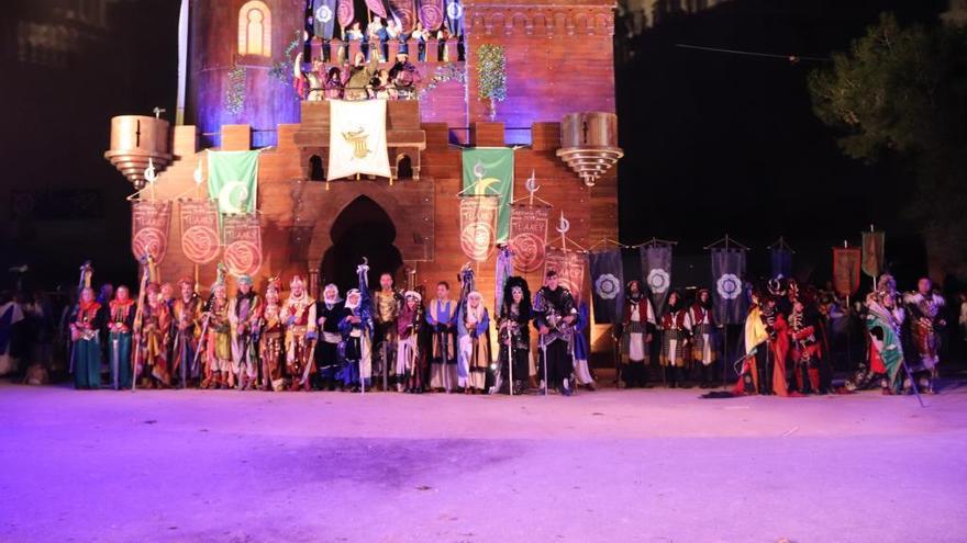 Participantes de una Embajada ante el castillo de fiestas en San Vicente del Raspeig.