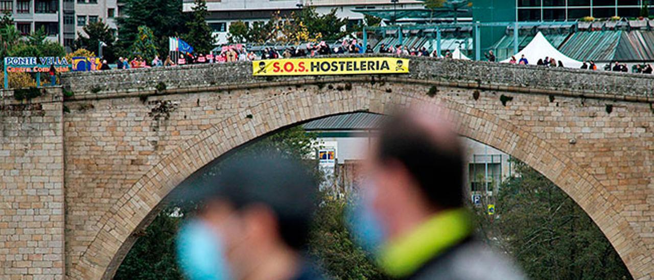 Un grupo de hosteleros se concentraron en el Puente Romano a la llegada de La Vuelta a la capital ourensana.