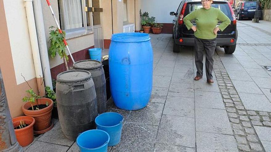 Una vecina espera a que Protección Civil le abastezca de agua. / carlos pardellas