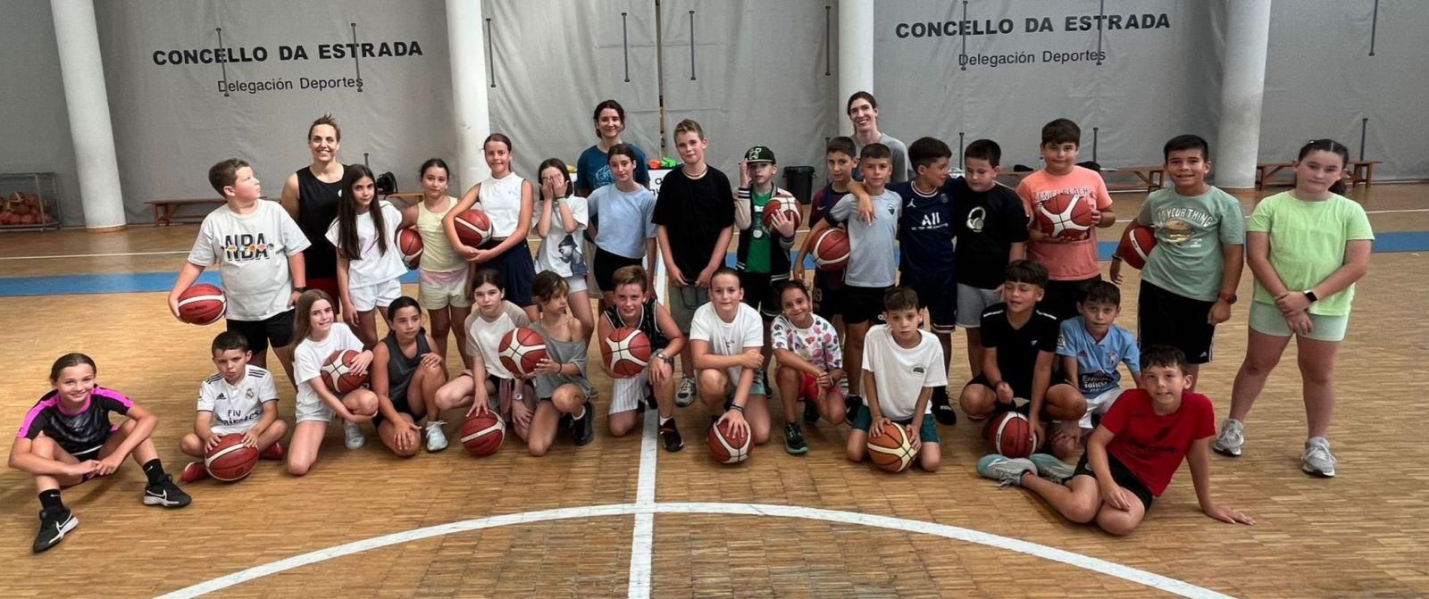 Niños y niñas del Campus Deportivo del Concello, junto a las tres jugadoras del A Estrada Basket, con Sabela Arranz en el centro.