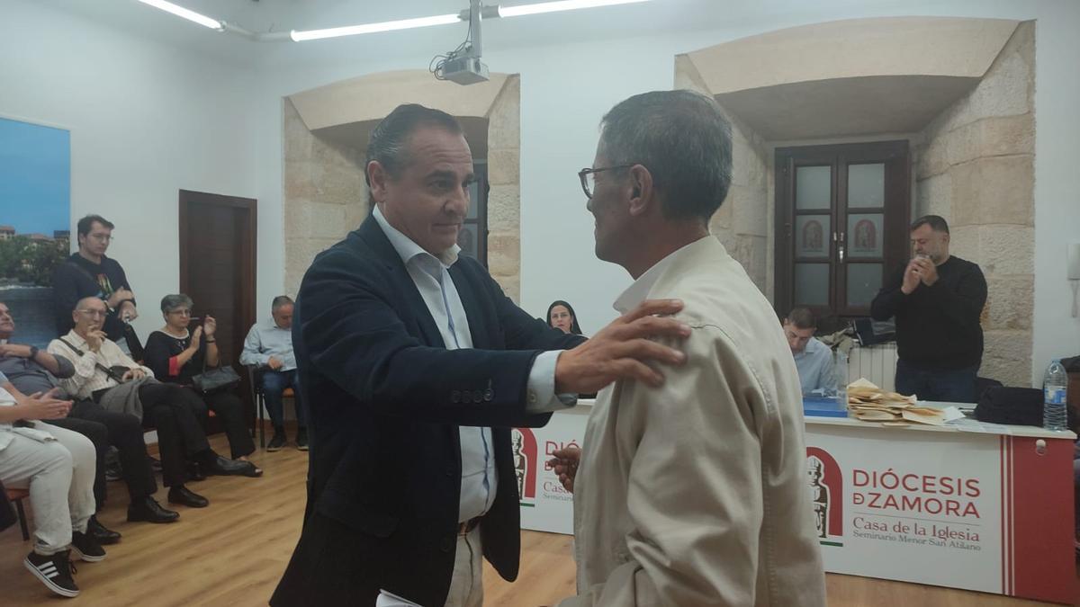 Manuel Cardo "Manín" da un abrazo al abad saliente, Antonio de la Higuera.