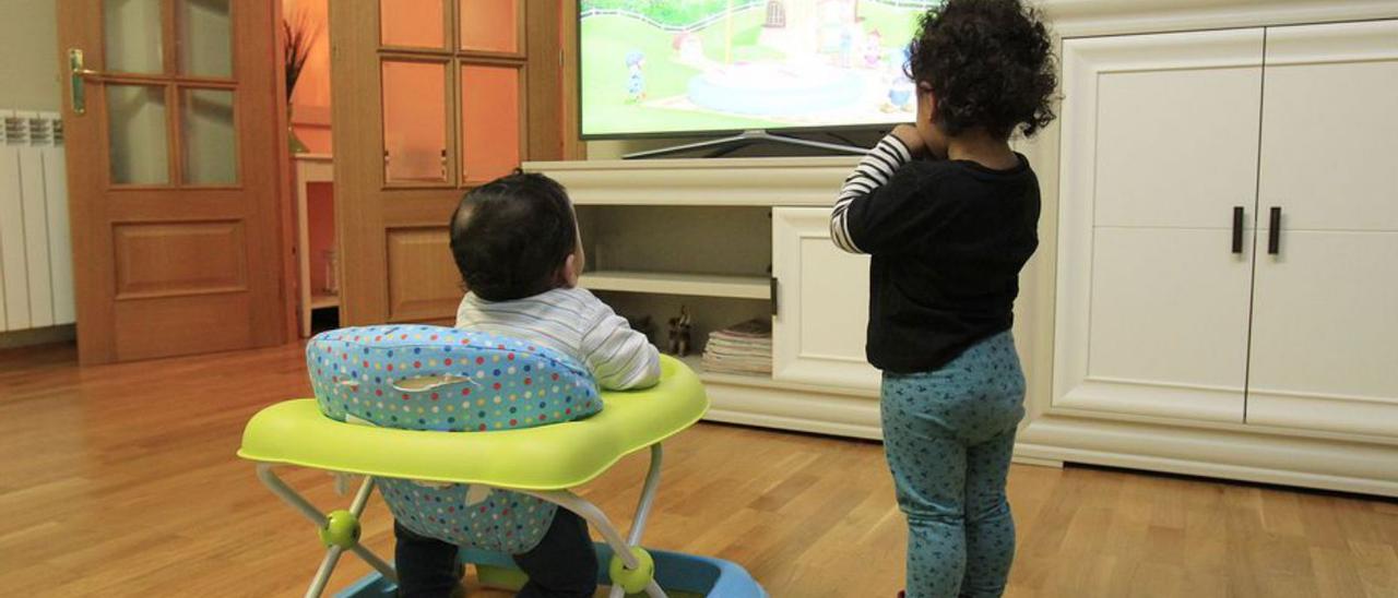 Dos nens miren la televisió en una casa d’acollida. | CHUS MARCHADOR