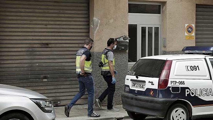 Dos agentes de la Policía Científica, a las puertas del edificio donde ocurrieron los hechos, en la calle Sant Joan Baptista de la Salle.