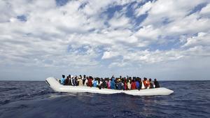 Refugiados a borde de un cayuco frente a la costa de Lampedusa, en Italia.