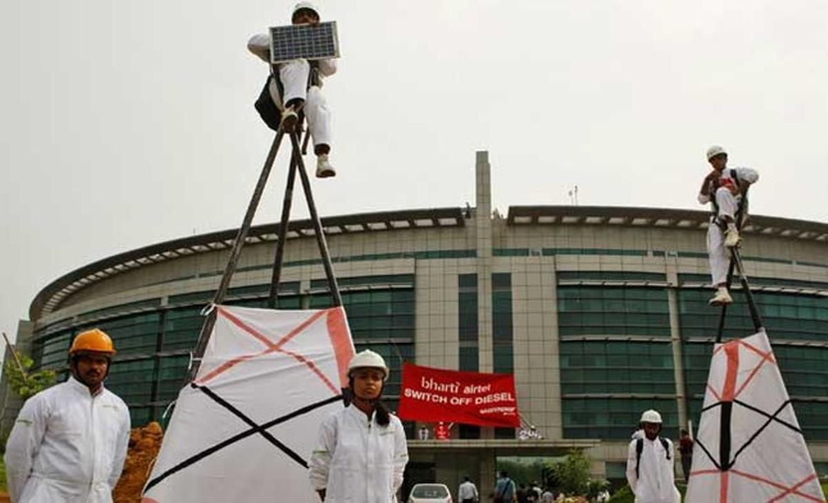 Uns activistes de Greenpeace es manifesten a sobre de dos models de torres de telecomunicacions mentre uns altres pengen una pancarta a la façana de l’empresa de telecomunicacions Bharti, a Nova Delhi.