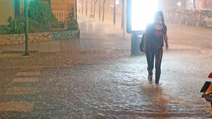 Una chica cruza una calle inundada de Ibiza el pasado 25 de septiembre por la noche.